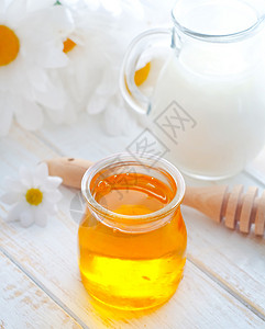 在玻璃库里的新鲜蜂蜜 和在罐中的牛奶治愈甘菊生产食物营养镜子玻璃金子产品早餐背景图片