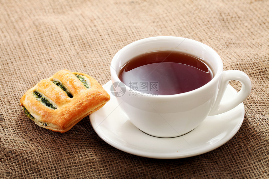 茶杯和桌布上的面包生活茶点勺子早餐糕点咖啡店黄油液体饮料午餐图片