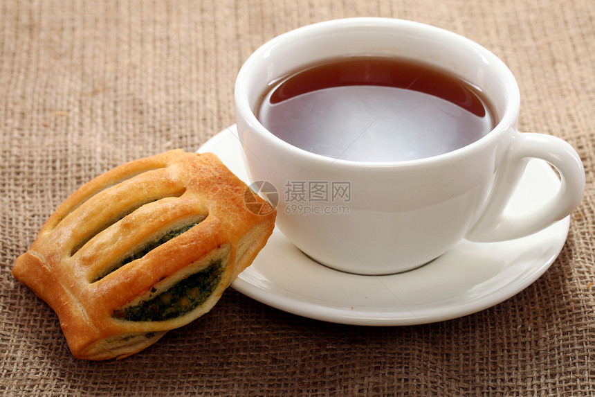 茶杯和桌布上的面包食物宏观休息茶点饮料饼干午餐甜点勺子杯子图片