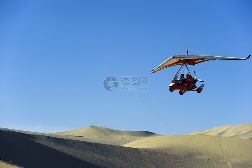 高压滑翔机在沙漠上空飞行图片