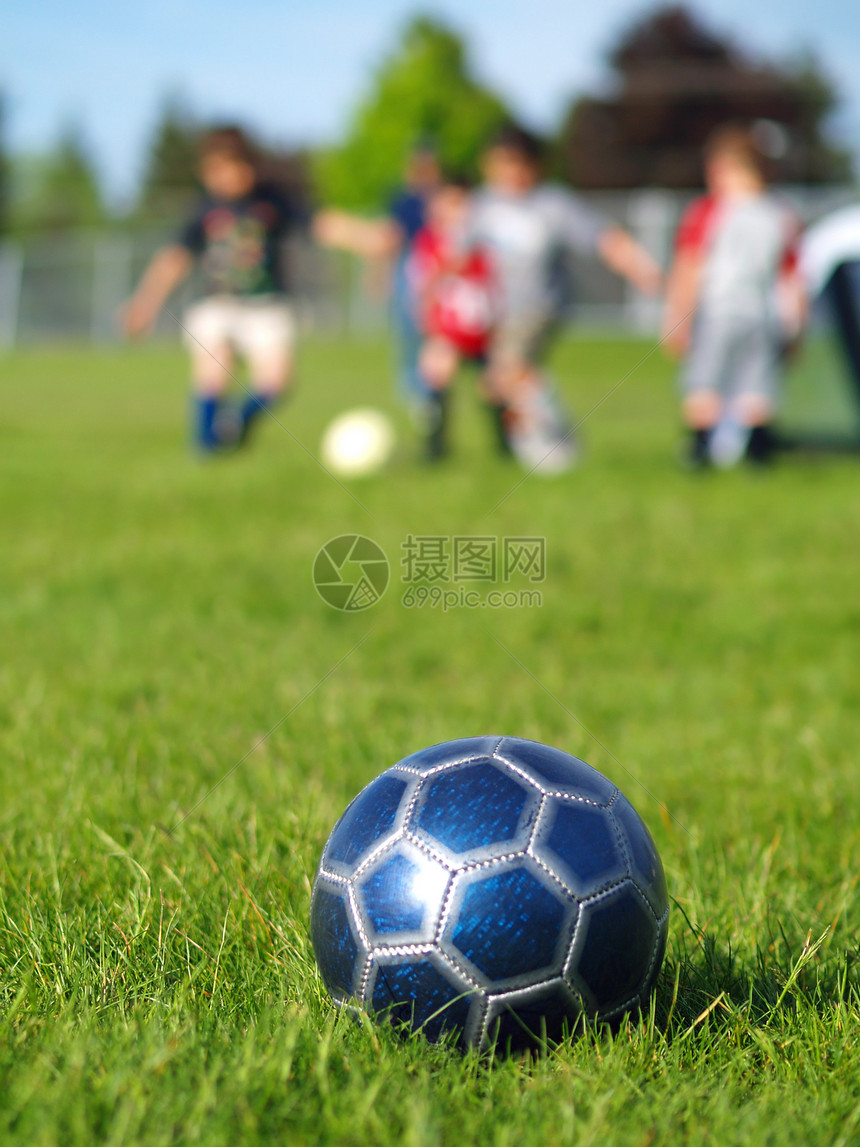 蓝足球球和玩家孩子闲暇草地分数阳光场地成功操场团队活动图片