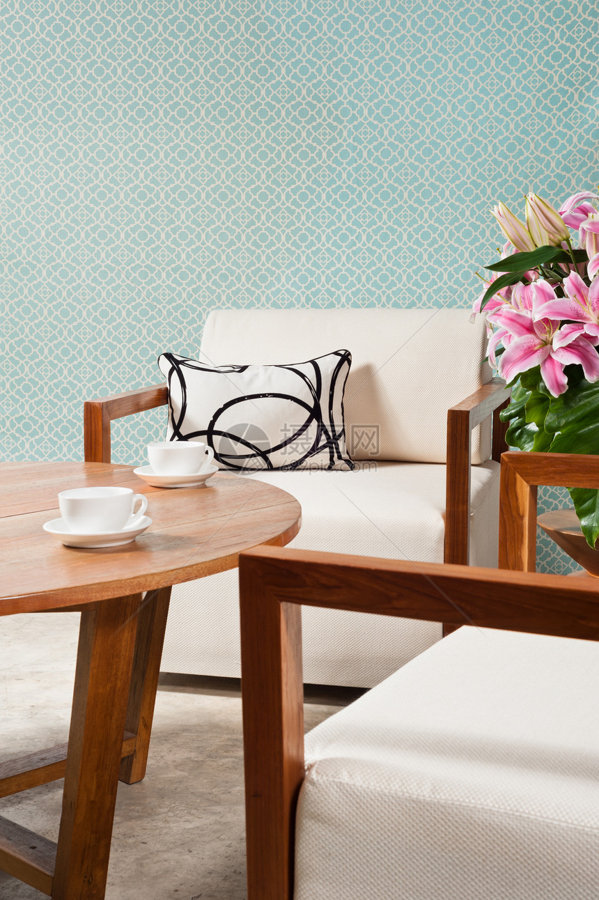 客厅中的棕白家具织物公寓房子扶手椅木头奢华枕头房间墙纸咖啡杯图片