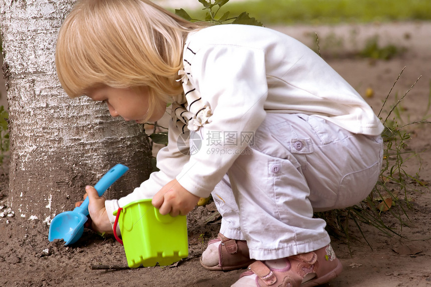 小女孩挖一个塑料铲子图片