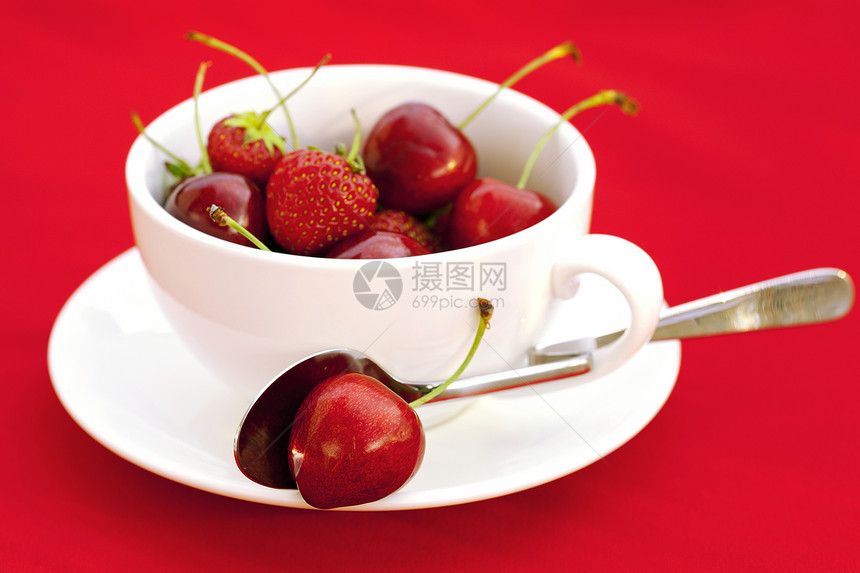 红背景的樱桃和草莓茶杯工作室餐具宏观杯子浆果盘子生活水果食物活力图片