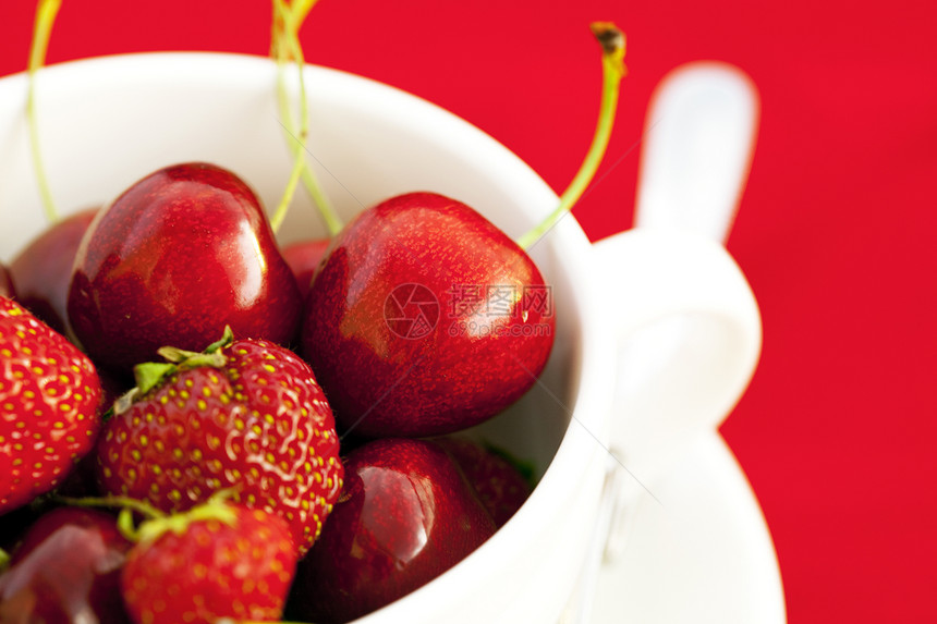 红背景的樱桃和草莓茶杯生活摄影宏观叶子小路活力盘子餐具浆果食物图片