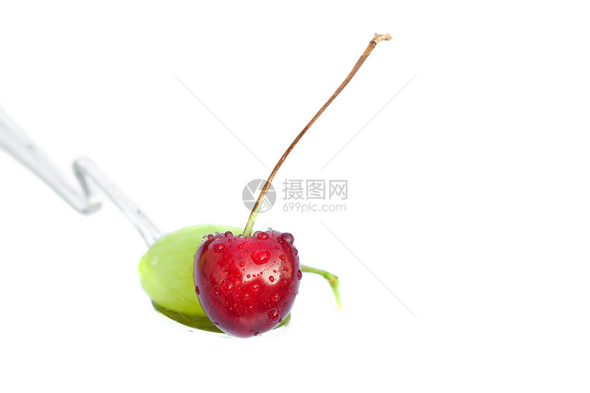躺在勺子里的葡萄和樱桃 被白的孤立图片