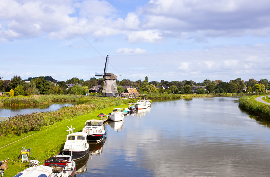 荷兰风力加小船在河边的荷兰风力厂建筑学历史生态蓝色溪流地标运河场景活力力量图片