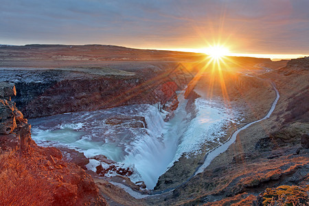 北极瀑布Gullfos 水瀑冰地活力流动日落景点阳光戏剧性旅游旅行火山瀑布背景