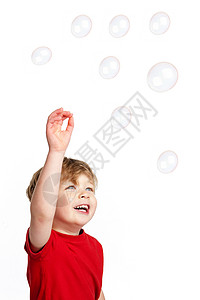红色泡泡玩泡泡的可爱男孩婴儿童年微笑青年儿子快乐乐趣孩子红色金发背景