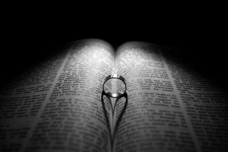 结婚戒指和圣经上帝婚姻宗教婚礼折叠遗嘱情感精神阴影反射背景图片
