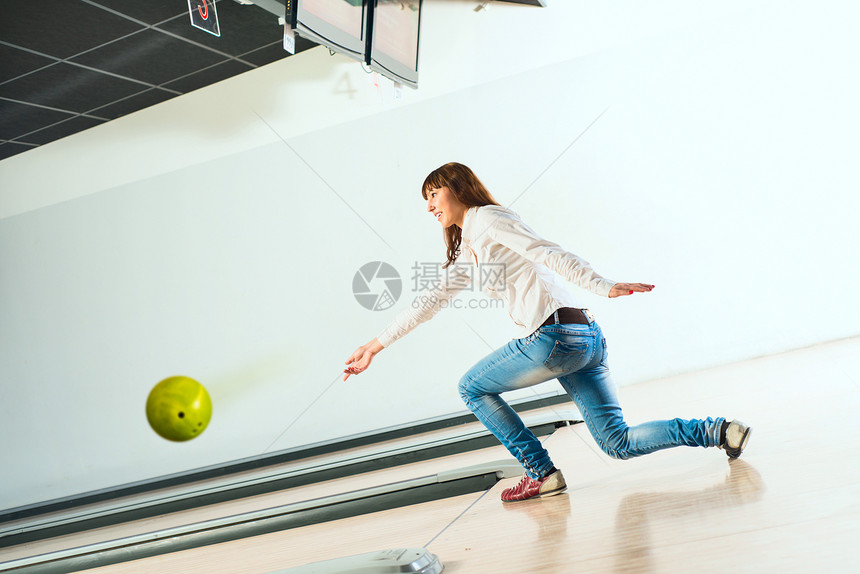 可爱的年轻女子扔了一个保龄球地面闲暇活动投掷女性手臂女士幸福蓝色友谊图片