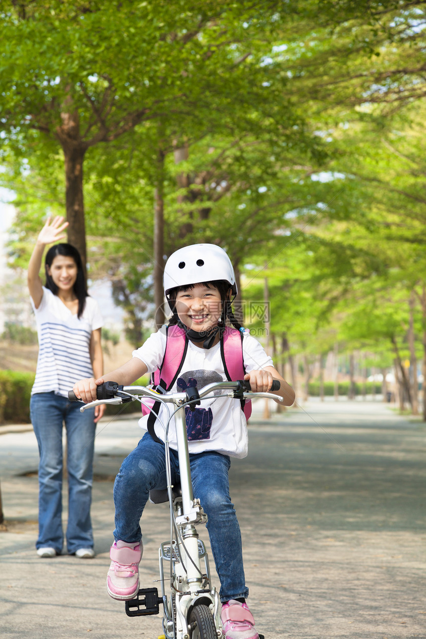 快乐的小女孩骑着自行车去上学图片