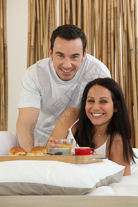 夫妇在床上吃早餐杯子男人咖啡托盘卧室窗帘面包夫妻羊角女士女孩高清图片素材