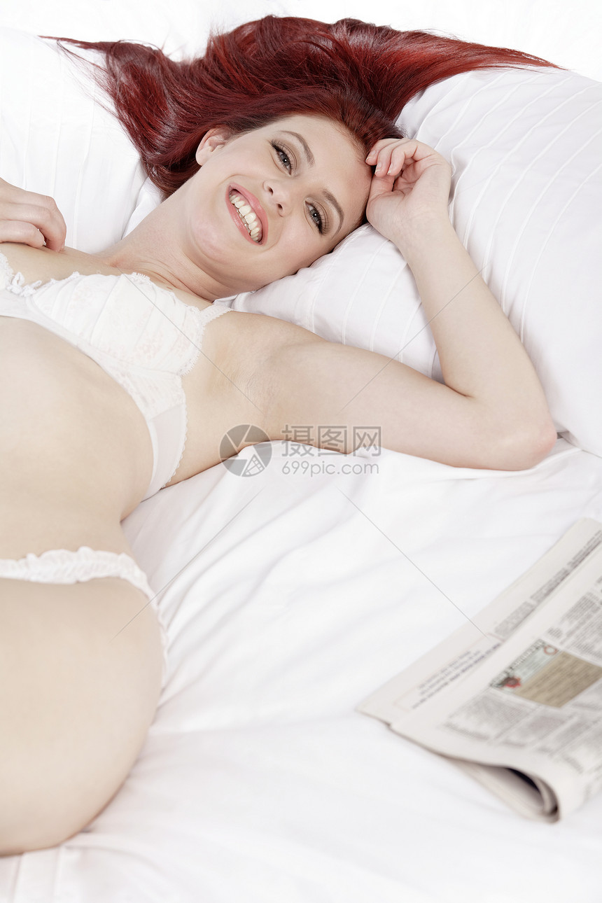 妇女穿着内裤躺在床上快乐内衣羽绒被微笑女士枕头女性图片