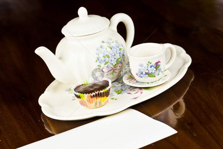 蛋糕加纸条和茶茶奶油咖啡杯子装饰黄色食物花朵白色桌子盘子图片
