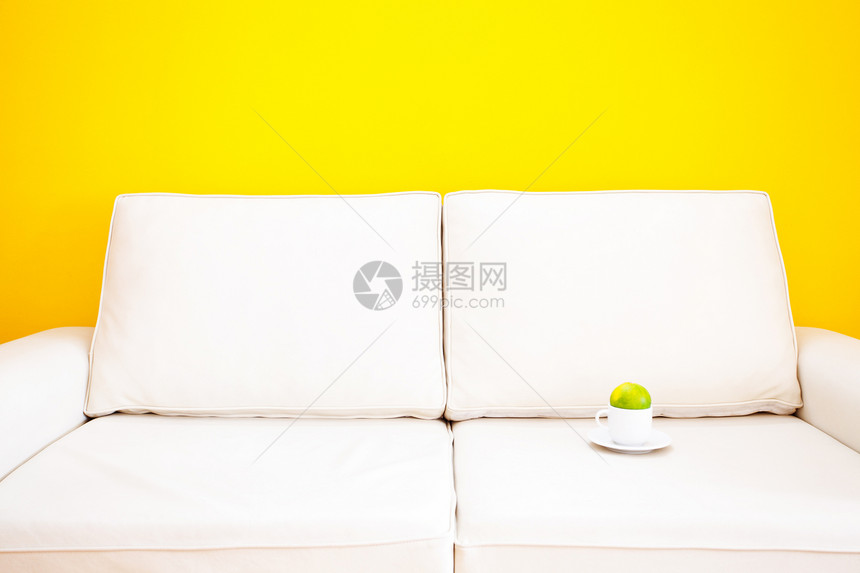 白沙发 用橘子杯杯子 靠在一面黄色的墙壁上建筑学食物房间长椅水果木地板皮革住宅长沙发家具图片