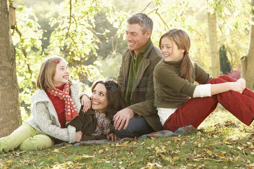秋天风景下放松家庭团群微笑公园女性女士女孩父母孩子孩子们男人母亲图片