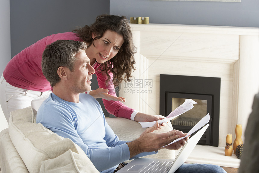 使用笔记本电脑和讨论家庭帐单的夫妇沙发闲暇女性办公男性居家个人微笑账单互联网图片
