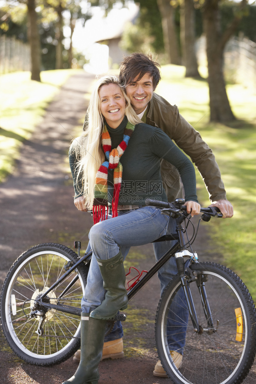 秋天公园中循环的年轻夫妇肖像男性服装季节休闲女士女性个人农村微笑夹克图片