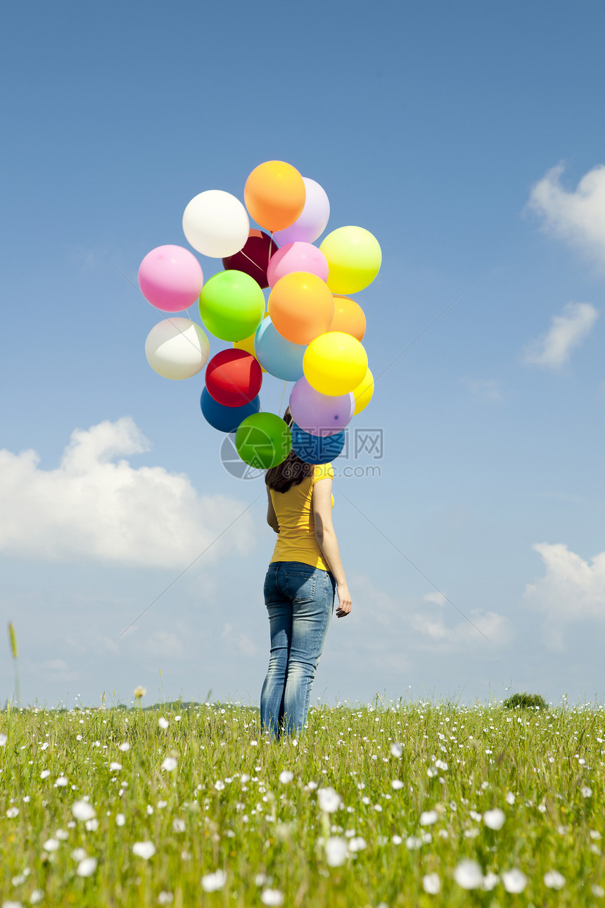 有彩色气球的女孩自由幸福波动成人喜悦天空草地享受快乐女性图片