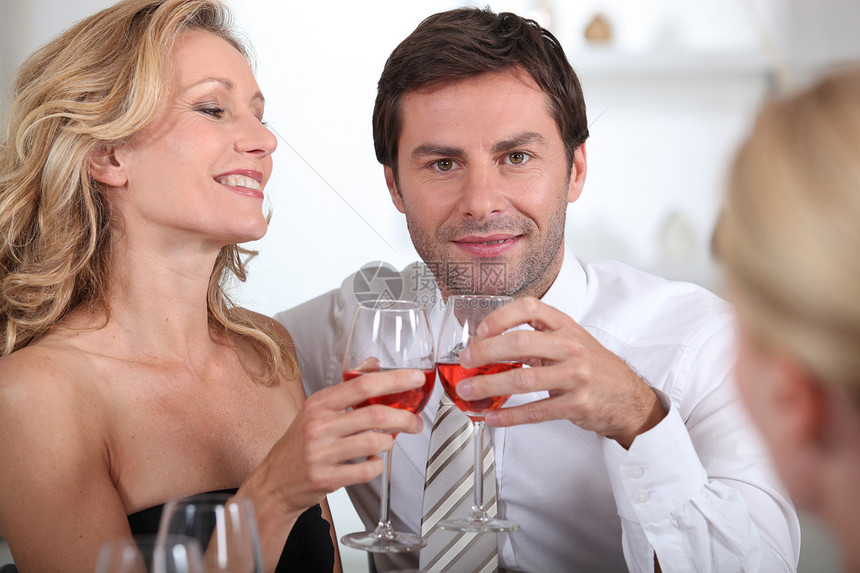 坐在一起的一对夫妇 一起拿着葡萄酒杯图片