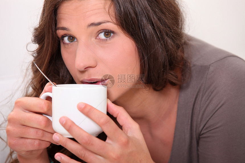 女人喝热饮咖啡前额女士饮料皱纹女性巧克力黑发工作室勺子