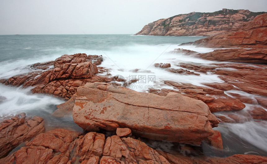 岩石海岸和模糊水域日出太阳天空石头海浪蓝色地平线边缘海洋热带图片