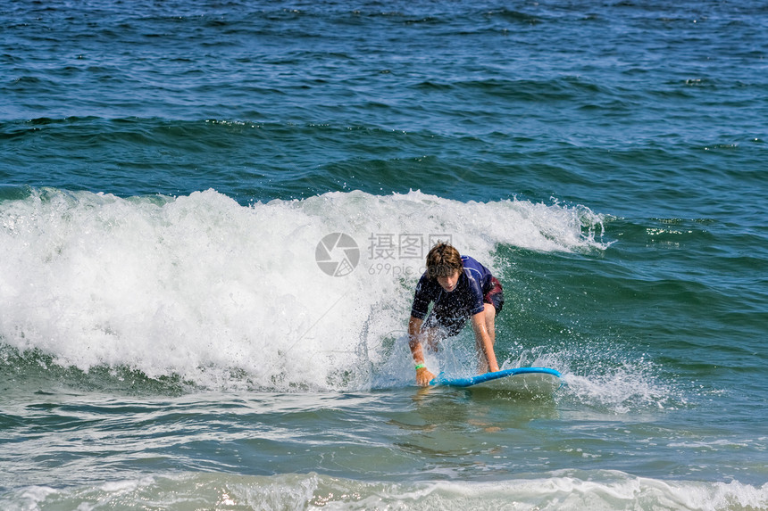 青少年游浪男孩们海浪休闲海洋趴板娱乐冲浪板支撑波浪男性图片