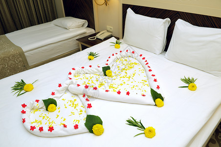 床上套房装满鲜花和毛巾已婚旅馆酒店寝具卧室婚礼枕头婚姻新娘背景图片