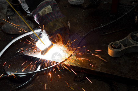 用火花焊接合的玻璃板工厂维修工具制造业冶金焊机辉光蓝色眼镜火焰背景图片