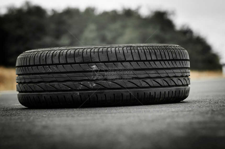 绿色背景的废弃汽车轮胎在路上停放运动速度橡皮黑色车轮旅行水平摄影轮缘运输图片