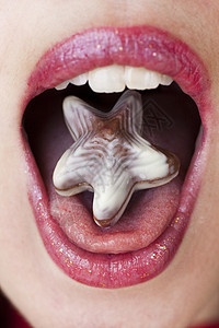 舌头上巧克力星乐趣牙齿诱惑女性嘴唇糖果品味白色甜点星星背景图片