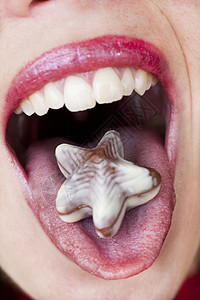 舌头上巧克力星宏观甜点星星口红牙齿女孩糖果品味白色诱惑背景图片
