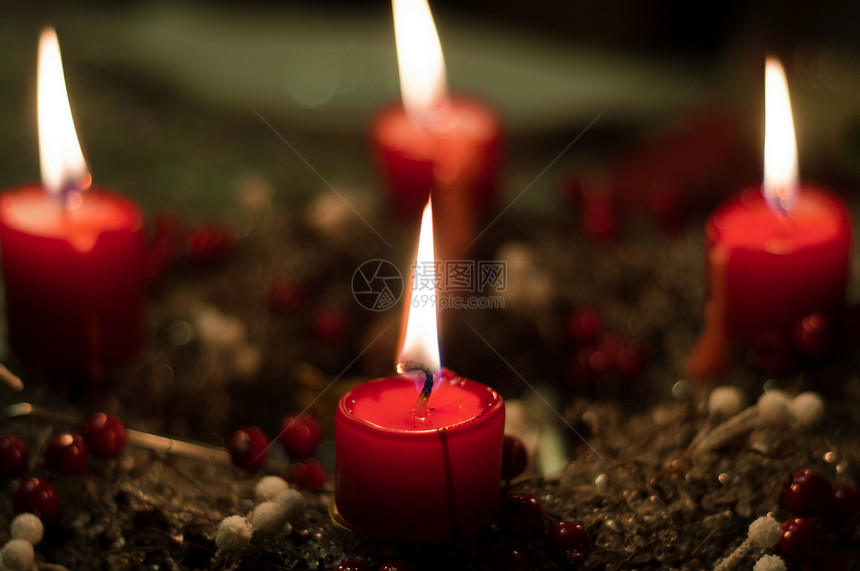 圣诞蜡烛在背着模糊背景的女孩上设备黑色燃烧照明火焰摄影传统选择性烛光焦点图片