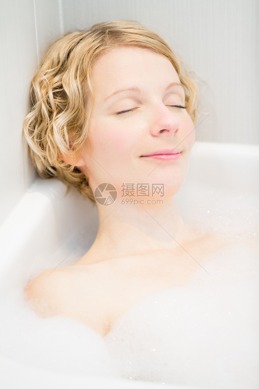 年轻女子在洗澡时放松温泉身体气泡女士快乐泡沫皮肤成人浴室肥皂图片