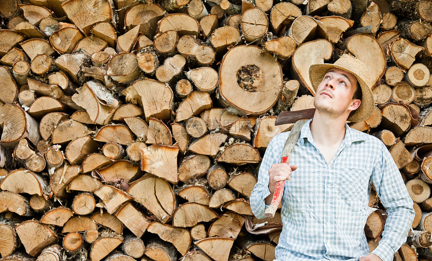 木头上戴草帽的木板匠稻草工人日志绳索林业刀刃活力男性帽子工作图片