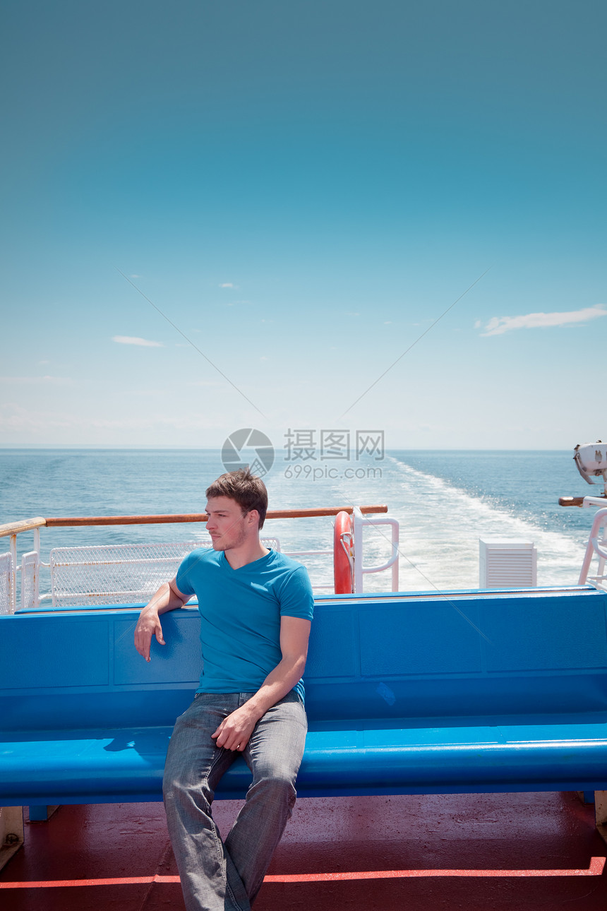 坐在甲板对岸海面的年轻人男人奢华蓝色水手闲暇运输美丽游艇自由幸福图片