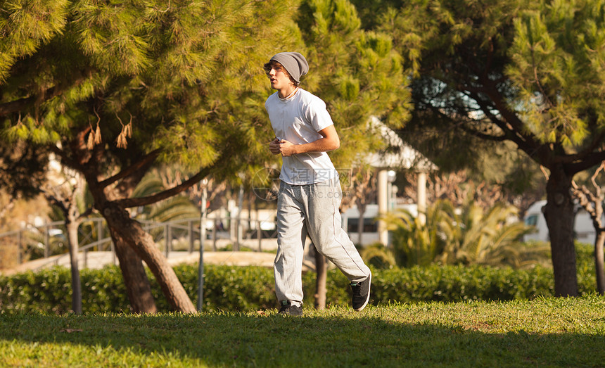 英俊的年轻人在公园里慢跑跑步身体训练男人娱乐运动肌肉活力运动员乐趣图片