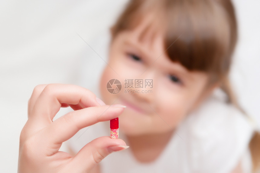 女人给小女孩吃药丸鼻子药片药品诊所寒意医生传染性疾病医院温度图片