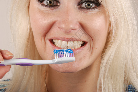 妇女刷牙牙刷牙科微笑蓝色幸福卫生白色浴室头发牙齿背景图片