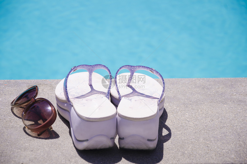 游泳池旁的女子用品假期人字水池拖鞋游泳太阳镜图片