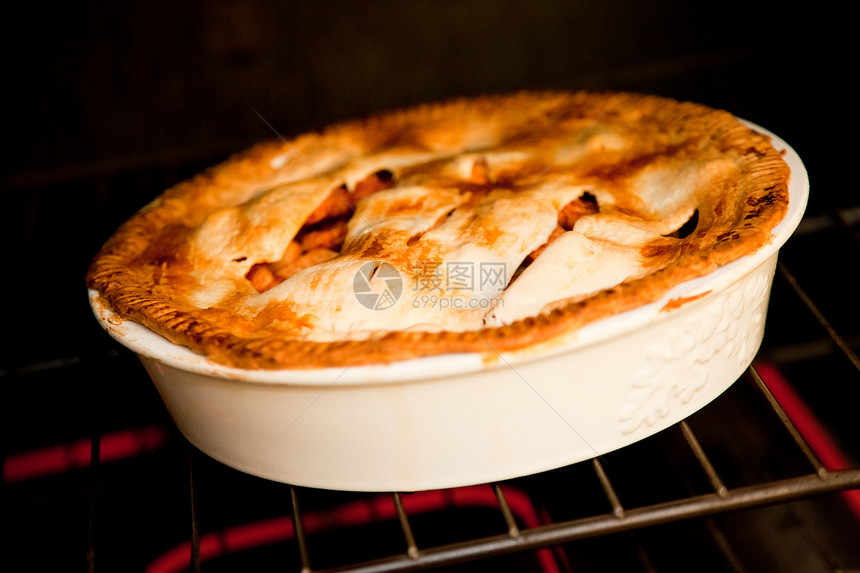 三个苹果派在烤炉里做饭烘烤食物甜点水平食品季节性馅饼小麦季节红色图片