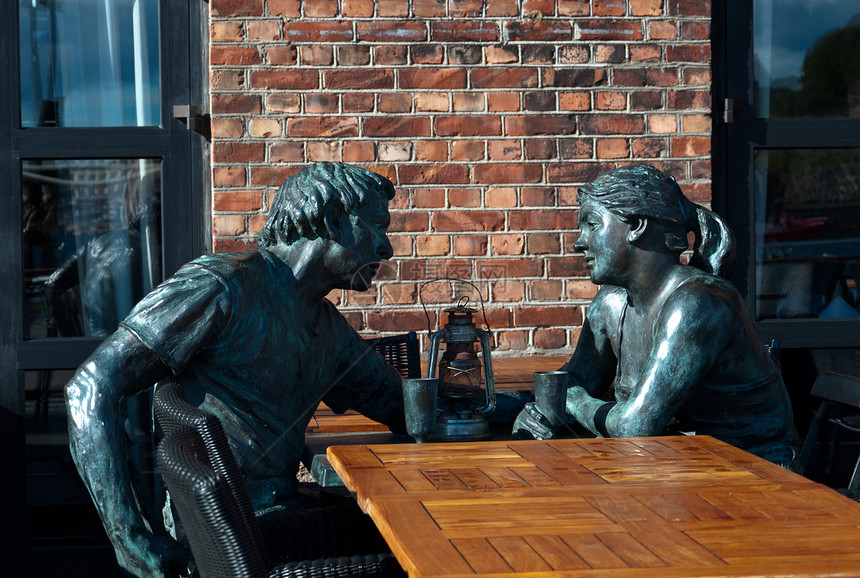 男男女女坐在酒吧桌前的雕塑图片