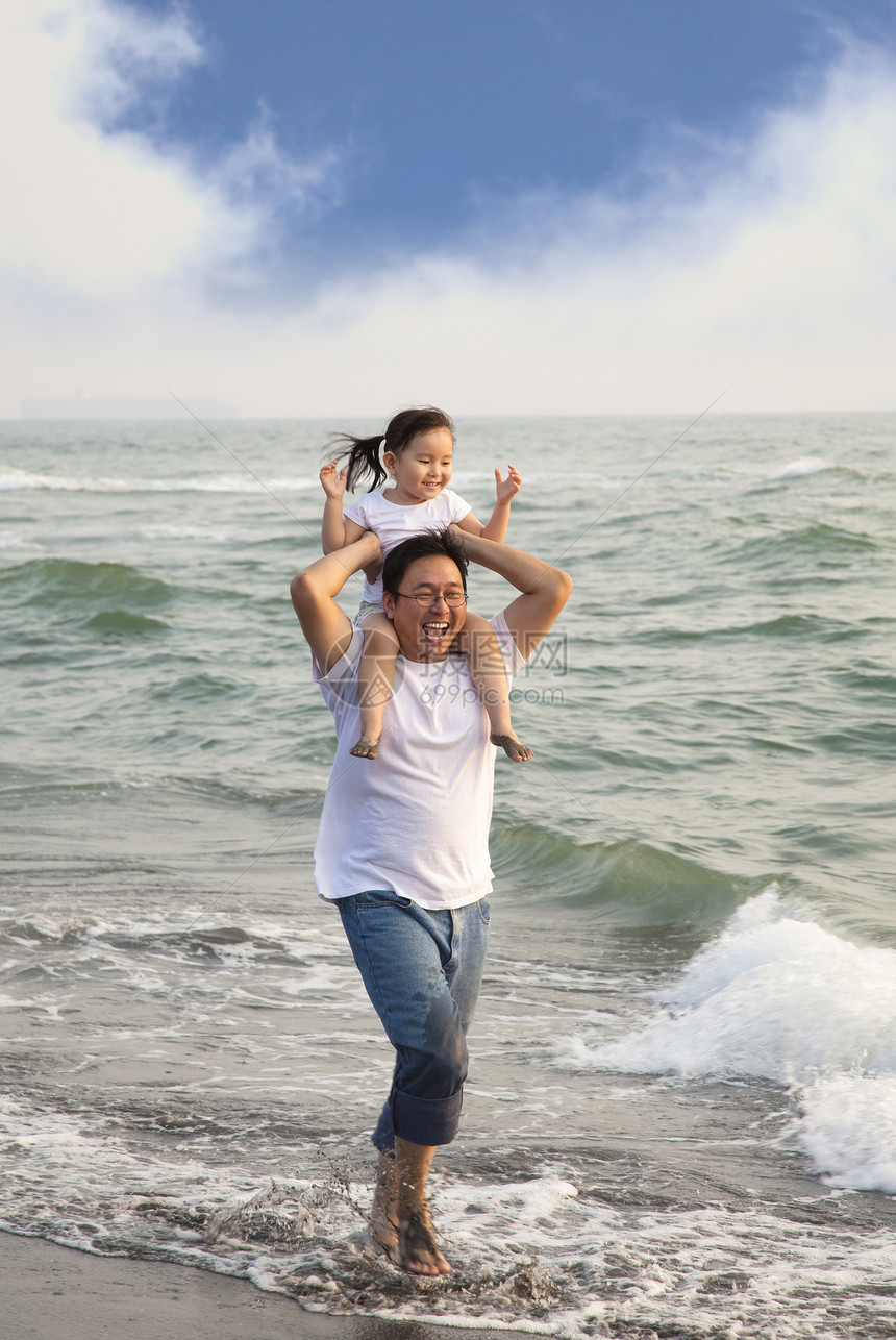 和小女儿一起快乐的父亲在沙滩上图片