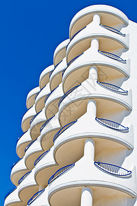 结盘蓝色建筑房子公寓晴天石头酒店栏杆旅游天空背景图片