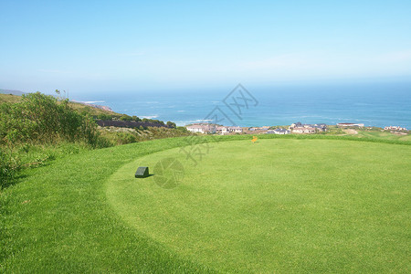 海洋周围高尔夫球道风景房子晴天高尔夫球发球台花园园艺波浪住宅环境爬坡背景图片