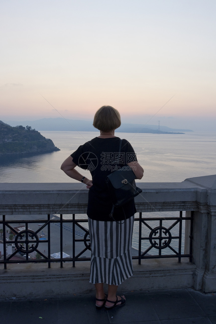 享受日落退休海滩阳台旅行游客海岸线旅游假期女士女性图片