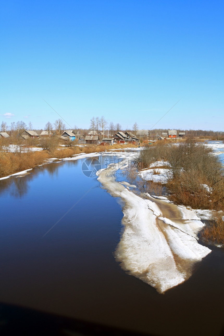 在靠近村庄的河流上驱冰房子小屋寒冷天空天气太阳季节寒意城市乡村图片