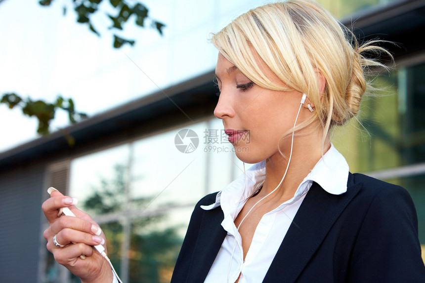 青年女商务人士倾听享受商业成人音乐白色耳机专注娱乐套装女士图片