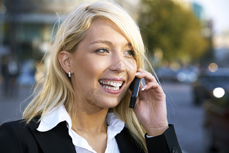 使用移动电话的快乐女商务人士金发喜悦商业商务女性手机成人人士背景图片